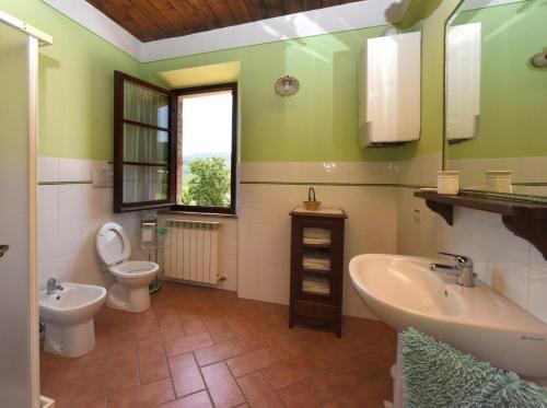 a bathroom with a sink and a toilet and a mirror at La Valle Del Sole - Val D'Orcia in Castiglione dʼOrcia