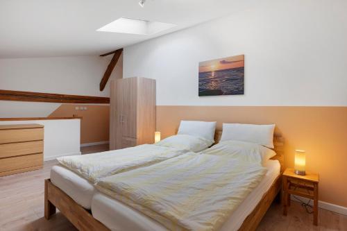 a large bed in a bedroom with two lights on at Ferienwohnung Junge 4 in Lohe-Rickelshof