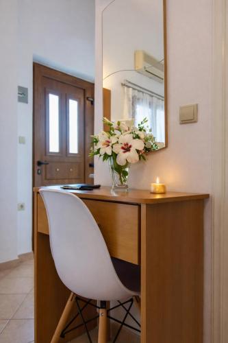 a vase of flowers on a desk with a white chair at 32sq Apartment with Balcony in Vlachopoulátika