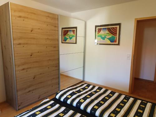 a bedroom with a bed and a wooden wall at Stadler in Langenargen