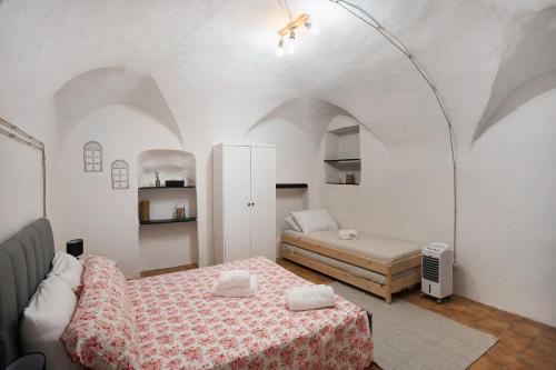 a bedroom with two beds in a room with arches at Casetta l'Ulivo in Poggi