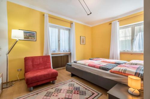 a bedroom with a bed and a red chair at Apartement Oase in Lana