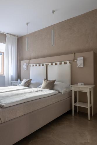 a bedroom with a large bed and a table at Rennweg 114 BELAMI LIVING in Merano