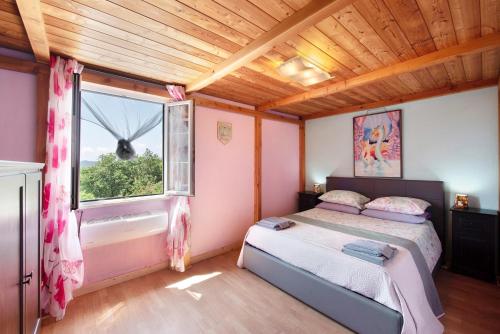a bedroom with a bed and a window at Barcollo House - Piscina nel verde in Stella