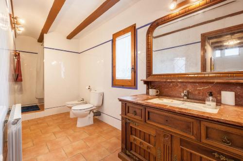 a bathroom with a sink and a toilet and a mirror at El Cup in San Martín de Tous