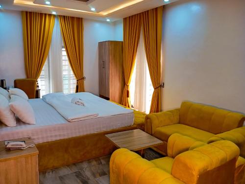 a bedroom with a bed and a couch at Joebrown Palace Hotel & Suite in Akitan