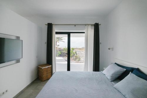 a bedroom with a bed and a large window at Casa Agua Nueva 53 in Frontera