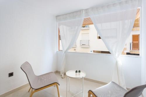 a white room with a table and chairs and a window at Lujoso cerca de playa in Jávea