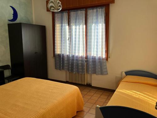a bedroom with two beds and a window at Luna Apartment in Rimini
