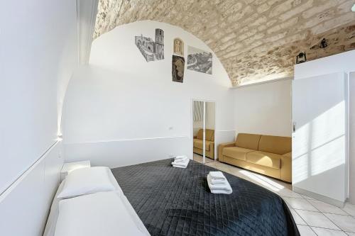 a room with two beds and a couch in it at La Castellana in Monte SantʼAngelo