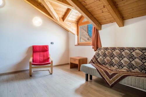 a room with a couch and a chair and a window at Casa Mirtillo Batistei in Molveno