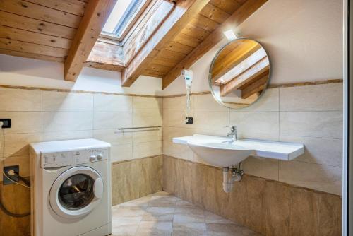 a bathroom with a washing machine and a sink at Casa Mirtillo Batistei in Molveno