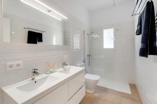 a white bathroom with a sink and a toilet at La Casa del Caballo in Adeje