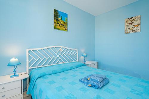a blue bedroom with a bed and two night stands at Casa Meli in Finestrat