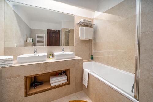 a bathroom with two sinks and a tub and a mirror at Villa Valentina in Carvoeiro