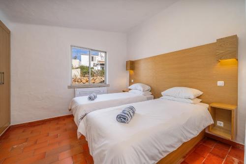 two beds in a room with a window at Villa Valentina in Carvoeiro