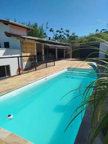 a large blue swimming pool in front of a house at Cachoeira Paulista Espaço Cassicay in Cachoeira Paulista