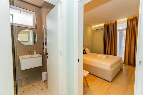 a hotel room with a bed and a sink at Fluctus Apartments in Durrës