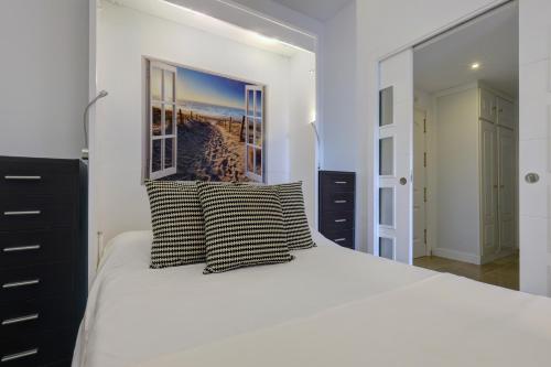 a bedroom with a large white bed with two pillows at Marina de la Duquesa 805 in Manilva