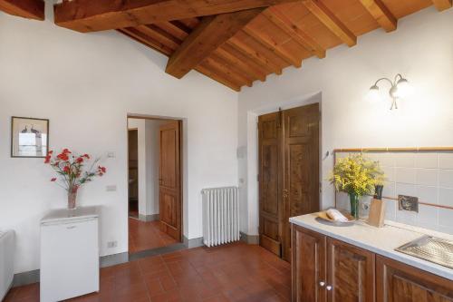 a kitchen with white walls and a wooden ceiling at Appartamento il Melo in Grassina