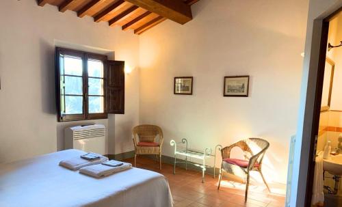 a bedroom with two chairs and a bed and a window at Appartamento il Melo in Grassina