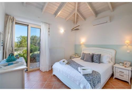 a bedroom with a bed and a large window at Villa Aloni in Lákka