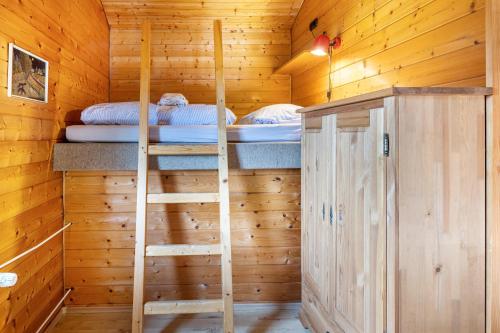 a room with two bunk beds in a wooden cabin at Sommerberg in Unterkirnach