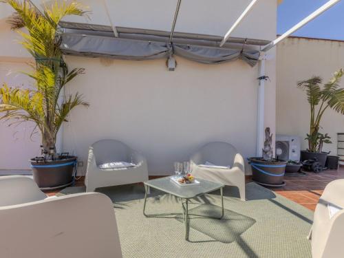 a patio with chairs and a table and plants at Apartment Coco Golf by Interhome in Sant Jordi