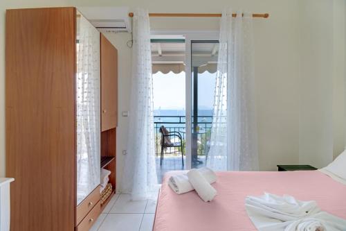 a bedroom with a pink bed and a balcony at S8 room in Nikiana