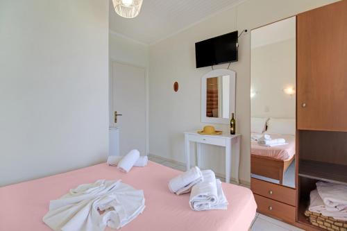 a bedroom with a pink bed with towels on it at S8 room in Nikiana