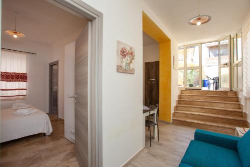 a living room with a blue couch and stairs at Appartamento Irgoli - Sardegna in Irgoli