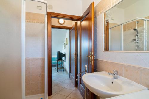 a bathroom with a sink and a mirror and a shower at Villamara in Olìa Speciosa