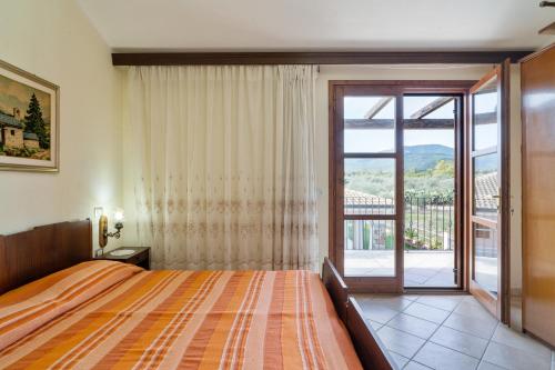 a bedroom with a large bed and a balcony at Villamara in Olìa Speciosa
