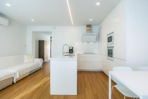 a white kitchen and living room with a white couch at Ca Na Tonina Ref 7000 in S'Illot