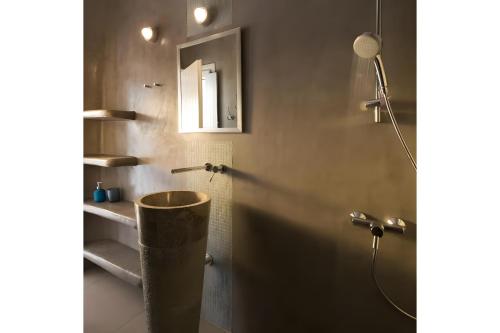 a bathroom with a shower with a sink and a mirror at Echinousa Kimolos katoikia no5 in Kimolos
