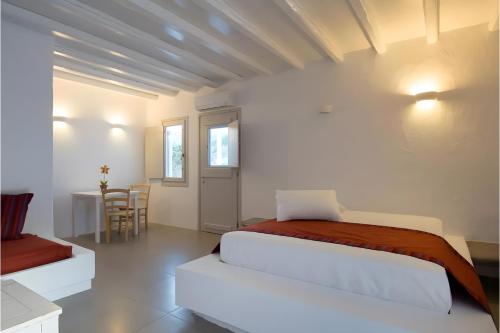 a white bedroom with a bed and a table at Echinousa Kimolos katoikia no5 in Kimolos