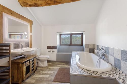 a bathroom with a tub and a sink and a toilet at Le Ranch Des Ours in Champsac