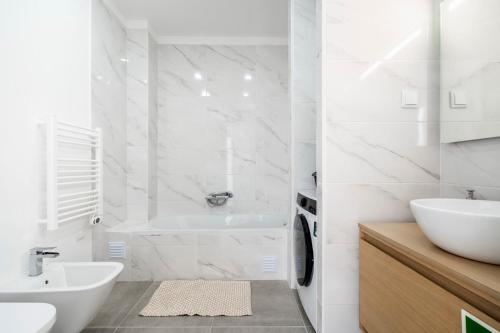 a white bathroom with a tub and a sink at Ptm Arade View Penthouse T3 Duplex in Portimão