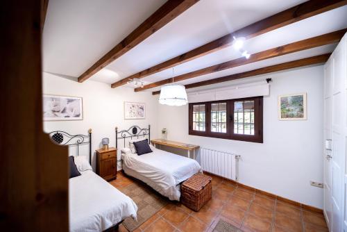 a bedroom with two beds and a window at La Jacaranda in Hornachuelos
