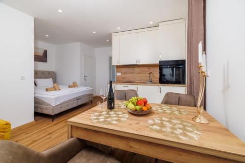 a kitchen and living room with a table with a bowl of fruit at Apartments San in Dramalj