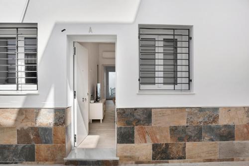 two views of a house with windows and a hallway at Apartamento Guzmán A in Barbate