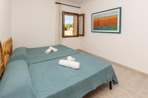 a bedroom with a bed with towels on it at Villa moli de ca n'orell in Santanyi
