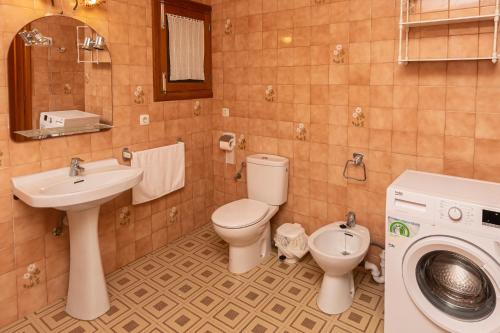 a bathroom with a toilet sink and a washing machine at Villa moli de ca n'orell in Santanyi