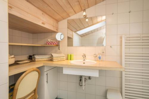 a bathroom with a sink and a mirror at Försterhaus Wohnung Dachgeschoss in Egg