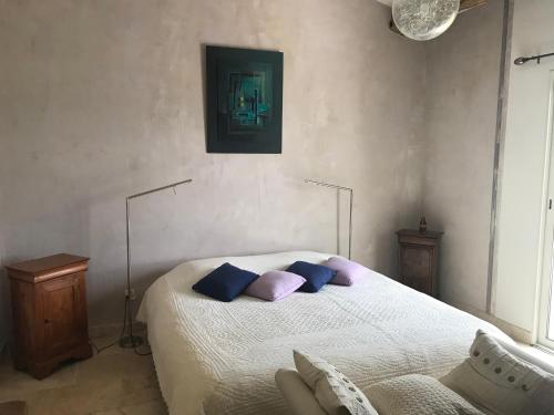 a bedroom with a bed with purple and blue pillows at Ferme du Luberon in Mane
