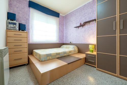 a small bedroom with a bed and a dresser at Casa García in L'Aldea