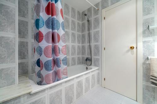 a bathroom with a shower curtain and a bath tub at Casa García in L'Aldea