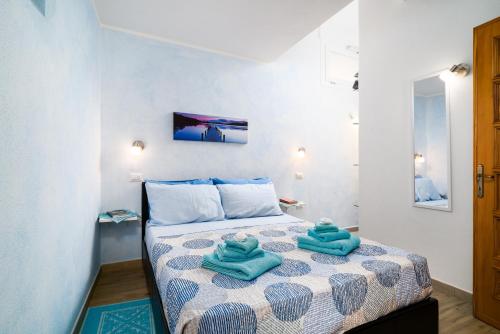 a bedroom with a bed with blue towels on it at Su Nidu Nou in Dorgali