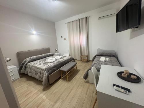 a bedroom with a bed and a desk and a table at Casa Concordia in Agrigento