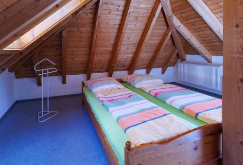 two beds in a attic room with wooden ceilings at Hinterhauensteinhof in Hornberg